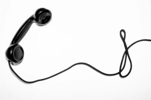 En gammaldags svart telefonlur med sladd.
